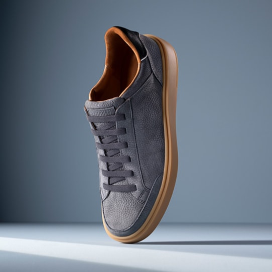 Men’s gray textured leather sneaker with tan rubber sole and brown leather lining